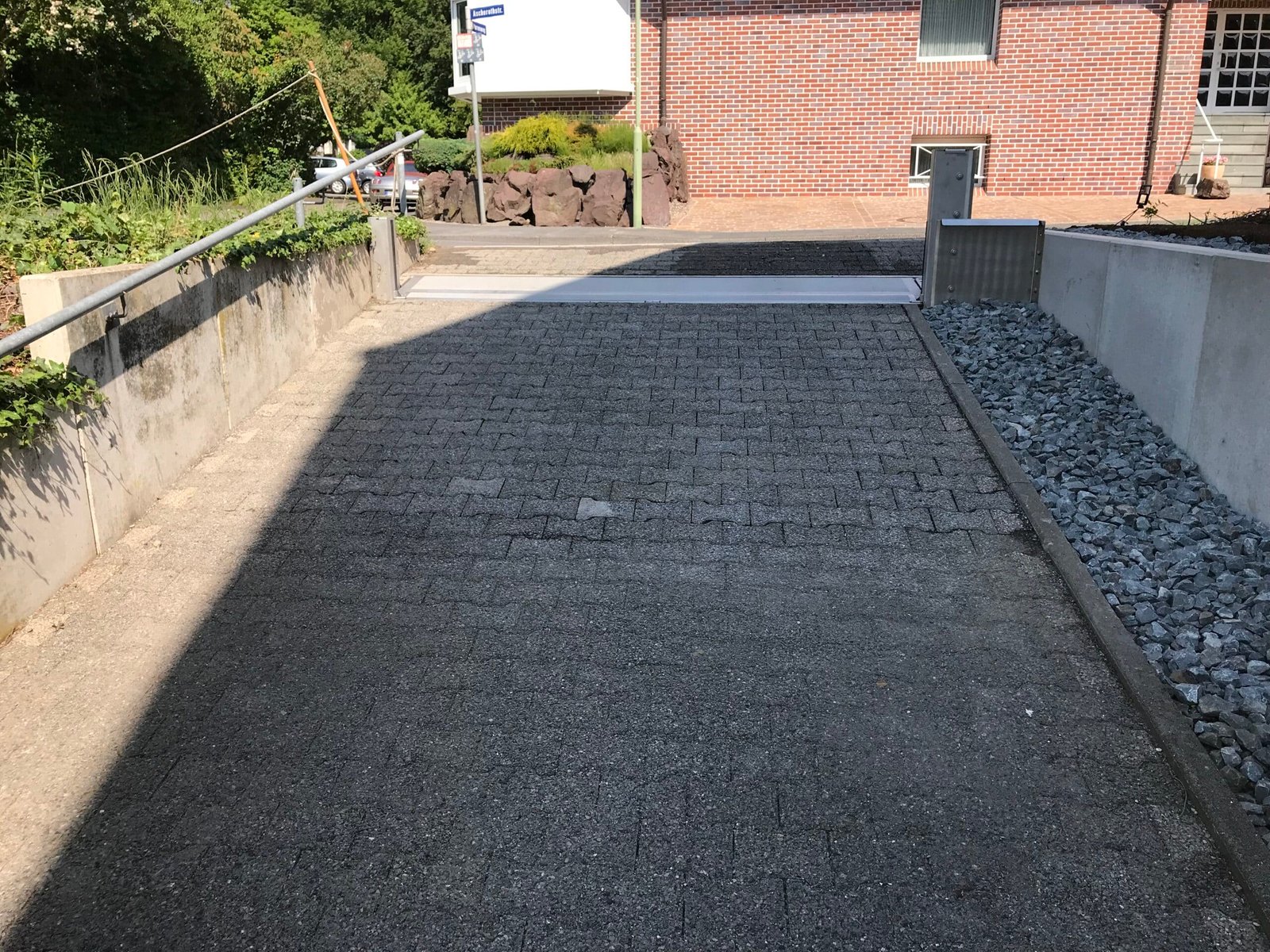 Fertig installierter Hochwasserschutz ohne Strom an Tiefgaragenzufahrt mit mechanischer Barriere