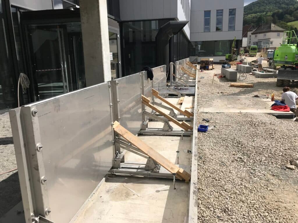 Installation mechanischer Hochwasserschutz-Barrieren aus Edelstahl ohne Strom an Gebäudezugängen