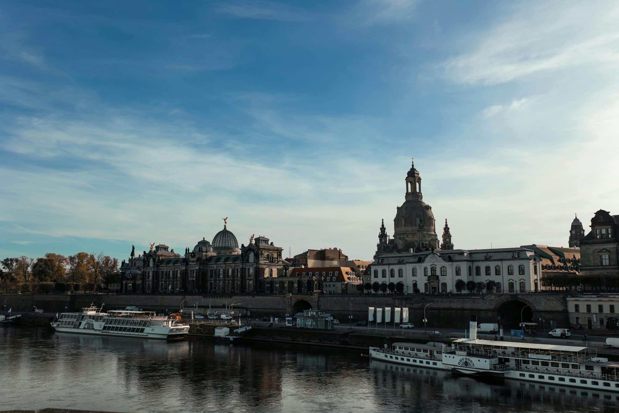 Wunderschöne Skyline von Dresden mit historischer Architektur entlang der Elbe und dort vor Anker liegenden Booten.