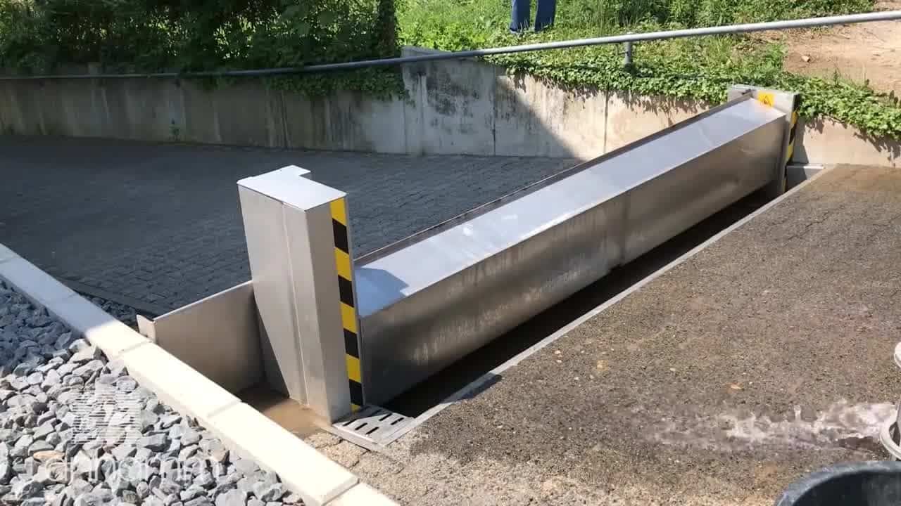 Vollautomatische Hochwasserbarriere aus Edelstahl von Anhamm an einer Garageneinfahrt – Schutz vor Sturzregen und Hochwasser